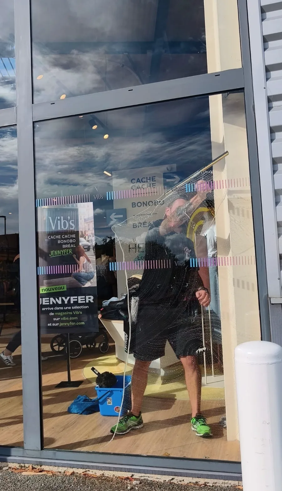 La même devanture vue à travers le verre savonné : la raclette descend en laissant une bande nette derrière elle