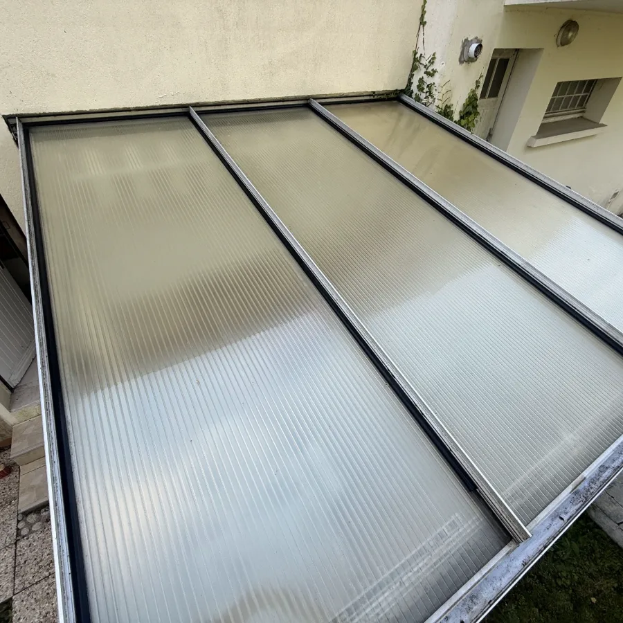 La même toiture de véranda après nettoyage : le polycarbonate est redevenu translucide et laisse de nouveau passer la lumière